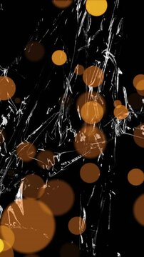 Animation of gold spots of light over light on moving shiny black plastic