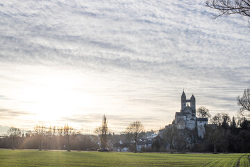 A winter landscape shot at sunrise. Plenty of nature and a large church on a rock. The former collegiate church of St. Lubentius Limburger, Dietkirchen, Hesse