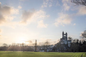 A winter landscape shot at sunrise. Plenty of nature and a large church on a rock. The former collegiate church of St. Lubentius Limburger, Dietkirchen, Hesse