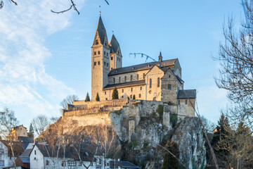 A winter landscape shot at sunrise. Plenty of nature and a large church on a rock. The former collegiate church of St. Lubentius Limburger, Dietkirchen, Hesse