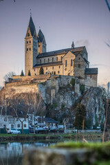 A winter landscape shot at sunrise. Plenty of nature and a large church on a rock. The former collegiate church of St. Lubentius Limburger, Dietkirchen, Hesse