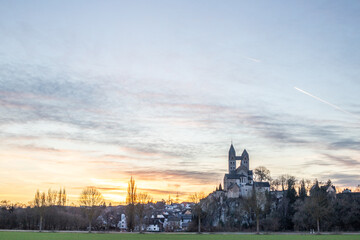 A winter landscape shot at sunrise. Plenty of nature and a large church on a rock. The former collegiate church of St. Lubentius Limburger, Dietkirchen, Hesse