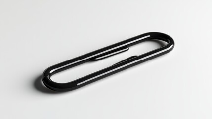 A sleek black metal paperclip lies flat on a clean white surface, showcasing its minimalistic and functional design.
