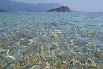 Stunning aerial view of Mogren Beach, Budva, Montenegro, with turquoise Adriatic sea, rocky cliffs,...