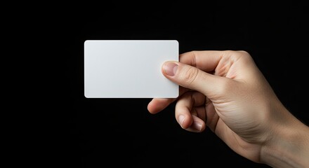 Hand holding blank card against black backdrop
