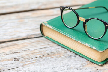 Vintage book and reading glasses create a cozy reading atmosphere