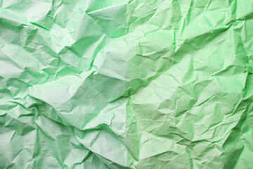 Obraz premium A crumpled green paper creates an abstract textured background