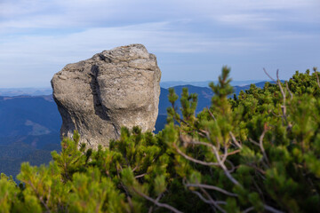 Majestic Natural Rock Formation Surrounded by Lush Greenery and Scenic Mountain Views Under a Clear...