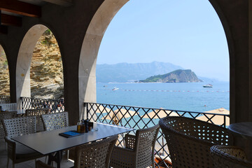 Stunning aerial view of Mogren Beach, Budva, Montenegro, with turquoise Adriatic sea, rocky cliffs, and a hidden sandy cove under a bright summer sky.