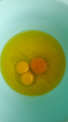 A Close-Up View of Fresh Eggs in a Light Blue Bowl Ready for Cooking, Showcasing Their Vivid Yolks and Clear Egg Whites for Culinary Inspiration and Delicious Recipes