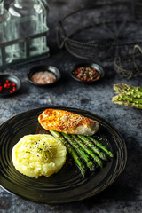 Grilled chicken breast with mashed potatoes and asparagus, sesame seeds topping