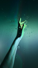 A Captivating Underwater Scene Featuring a Hand Reaching Upward Surrounded by Bubbles and a...