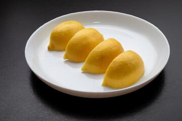 Lemon slices on white plate. Freshness concept, making lemonade with lemon slices. Summer cold...