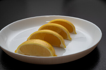 Lemon slices on white plate. Freshness concept, making lemonade with lemon slices. Summer cold...