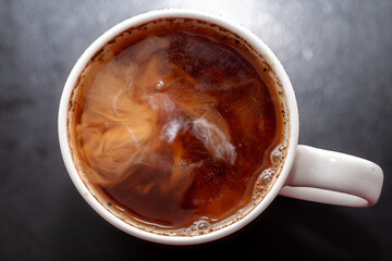 Detail of milk mixing in coffee drink, flat texture. Fresh beverages background