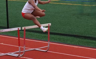 Athlete Jumps Over Hurdles During a Track Hurlde Rac3e
