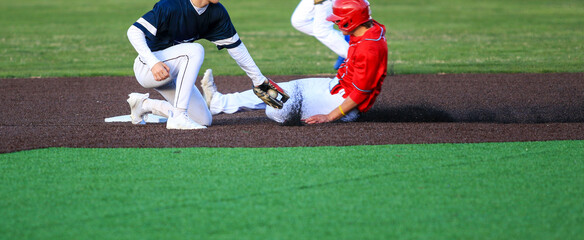 Runner Sliding into Second Base with the Short Stop Trying to Apply the Tag During a Baseball Game