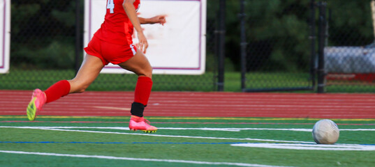 Soccer Player chasing the Soccer Ball During a Game