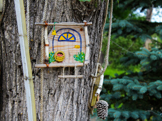 Creative wooden bird feeder on a tree.