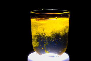 Close-up: Turmeric Particles Dispersing in Water