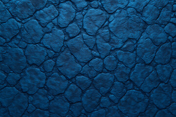 Close-up of a textured, dark blue surface resembling stone or cobblestone, with irregular shapes and deep crevices.