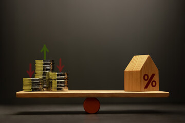 Stacked coins money and houses balanced on a scale seesaw. Mortgage interest rates, House Loan and real estate investment