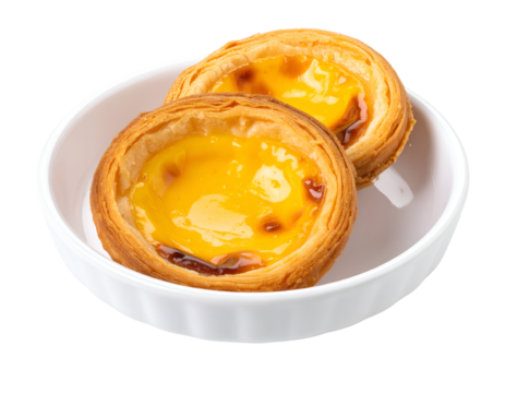 Two golden Portuguese egg tarts with flaky pastry and creamy custard filling are presented in a simple white bowl.