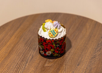 A beautifully decorated traditional Easter cake with icing and pastel toppings on a rustic table.