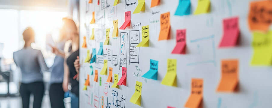 Team brainstorming with colorful sticky notes on whiteboard in bright office space