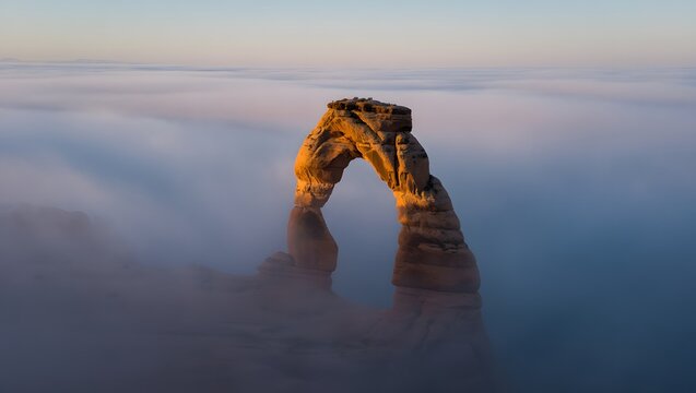 Delicate arch utah aerial view at sunrise in fog and clouds national park landscape