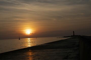 Riga, Latvia 05-09-2024 A Sunset Over the Sea with Silhouetted Lighthouses