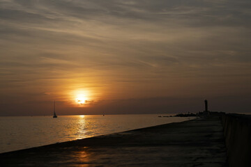 Riga, Latvia 05-09-2024 A Sailboat's Journey Across the Tranquil Seas at Sunrise