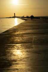 Riga, Latvia 05-09-2024 Silhouetted against the golden hour, a tranquil evening unfolds as people...