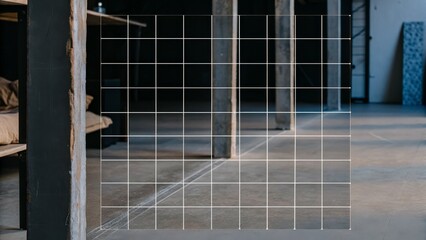 An industrial-style interior space with concrete floors and pillars, featuring a white wireframe grid overlay demonstrating 3D spatial dimensions.