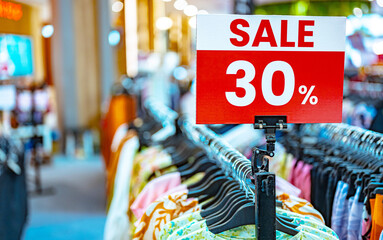 A sign with a seasonal price reduction at a clothing store