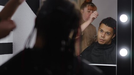 A skilled hair stylist meticulously works on a clients hair, showcasing an impressive and trendy haircut process