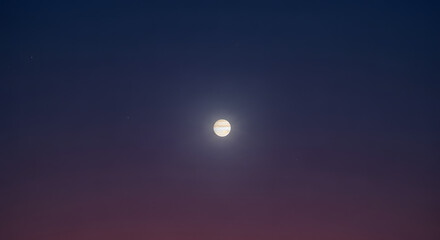 The planet Jupiter shines brightly in the dark, starry night sky with a gradient of blue to red color.