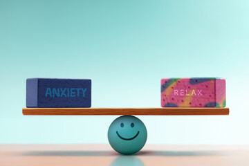 Anxiety and Relax cube balancing on seesaw, centered by  Smiling Ball. symbolizing Mental Health and Emotional self regulation through balancing positive and negative emotions