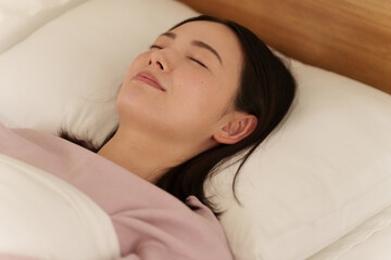 夜ベッドで寝る女性
