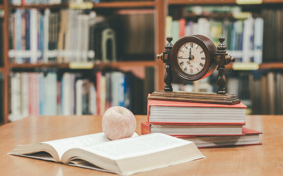 History education, historical law, literature, philsophy class, academic knowledge concept with aged clock on stack of old textbook document archive record in school library or classroom background