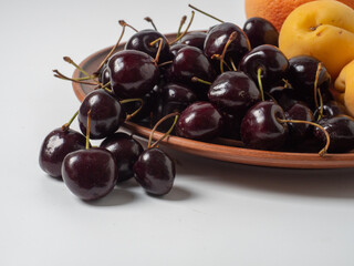 Sweet cherries with apricots isolated on white background cutout. Ripe berries closeup. Mix berries and fruits.