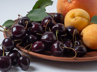 Sweet cherries with apricots isolated on white background cutout. Ripe berries closeup. Mix berries and fruits.