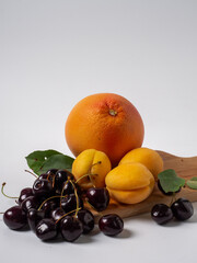 Sweet cherries with apricots isolated on white background cutout. Ripe berries closeup. Mix berries and fruits.