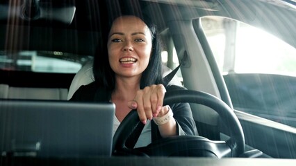 Smiling young woman using seat belt and enjoying drive in the city. Safety driving, transport,...
