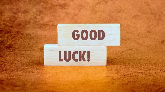 The phrase GOOD LUCK appears on a wooden block. Animation of the words GOOD LUCK. Business and Good luck concept.