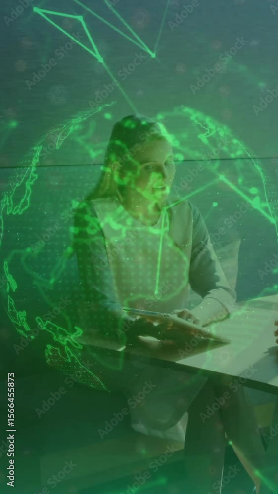 Poster two women discussing at table with digital globe and network animation overlay