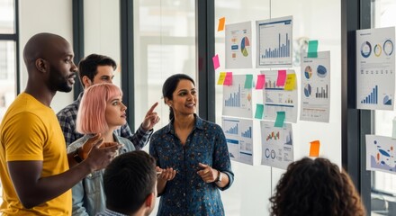 Team of diverse professionals brainstorming ideas in front of a whiteboard with data charts during a business meeting.