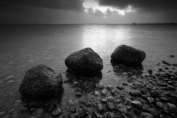 A black and white photo of three rocks in the water