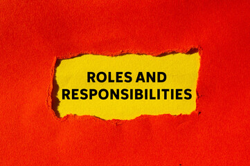 Roles and responsibilities message written on ripped torn red paper on yellow background....