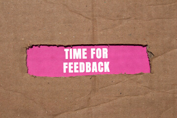 Time for feedback message written on ripped torn cardboard paper on pink background. Conceptual...